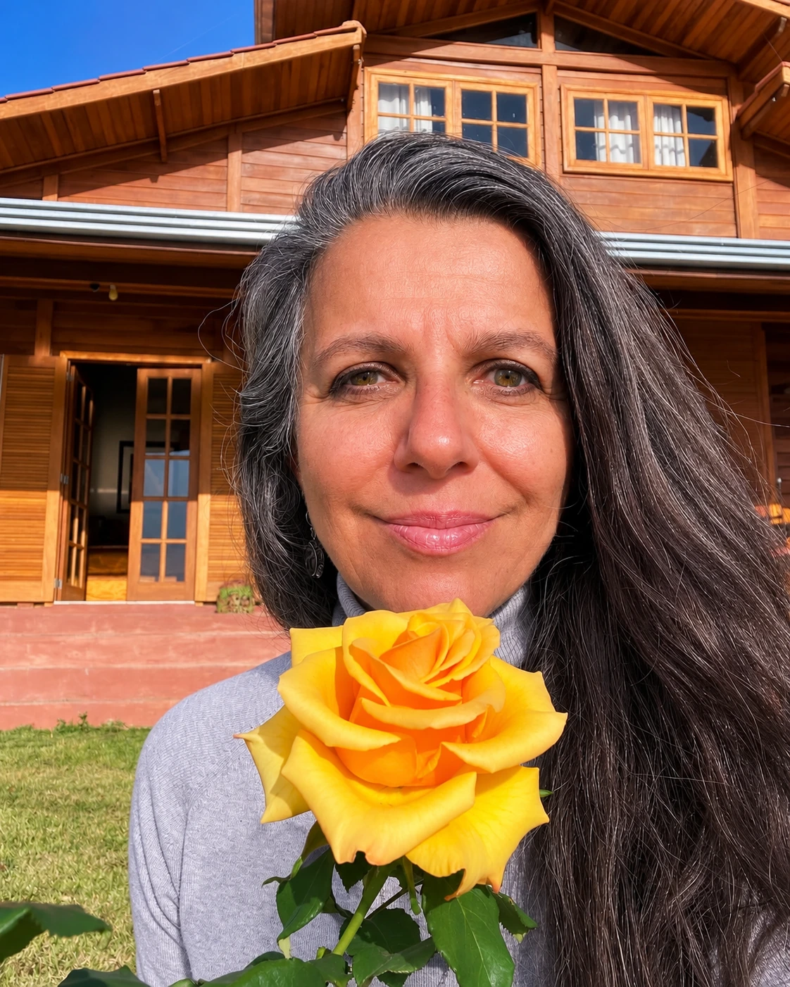 Adriana segurando uma rosa amarela.