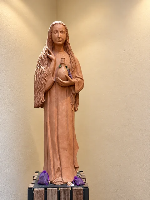 Escultura de uma figura feminina segurando um recipiente.