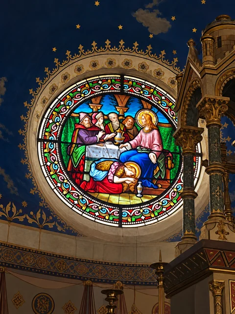 Vitral circular colorido em um interior azul e dourado.