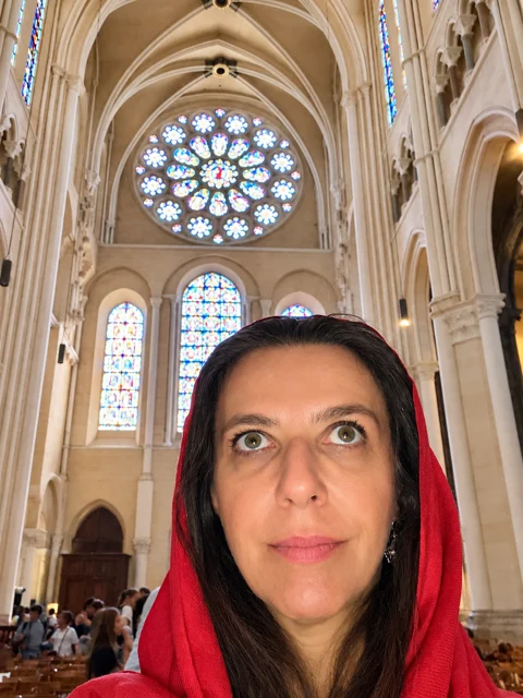 Adriana no interior de uma igreja com arcos altos.